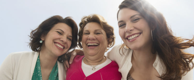 Three generations of women smile into the camera