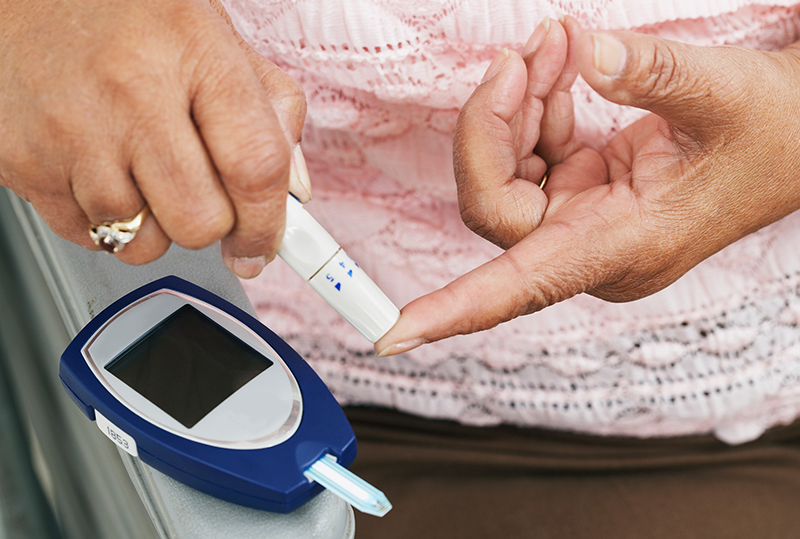 a woman testing her glucose level on her finger