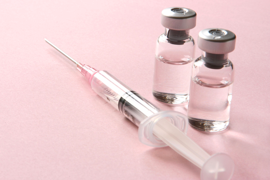 needle syringe and two bottles of vaccine