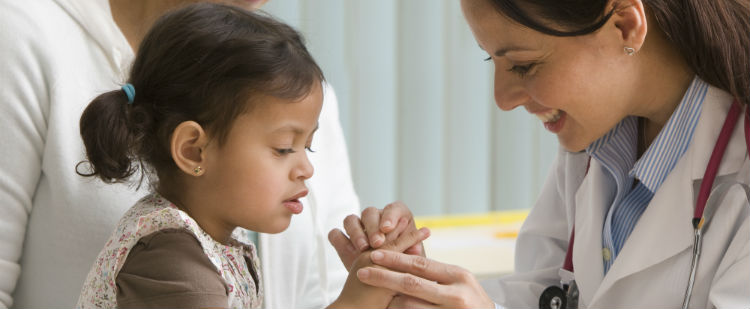 female child being examined by smiling female doctor