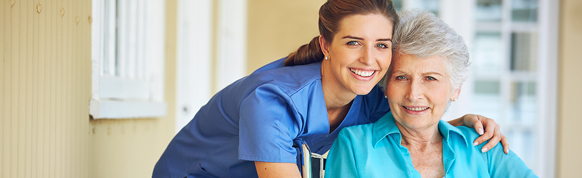 a health care provider hugging a senior female patient