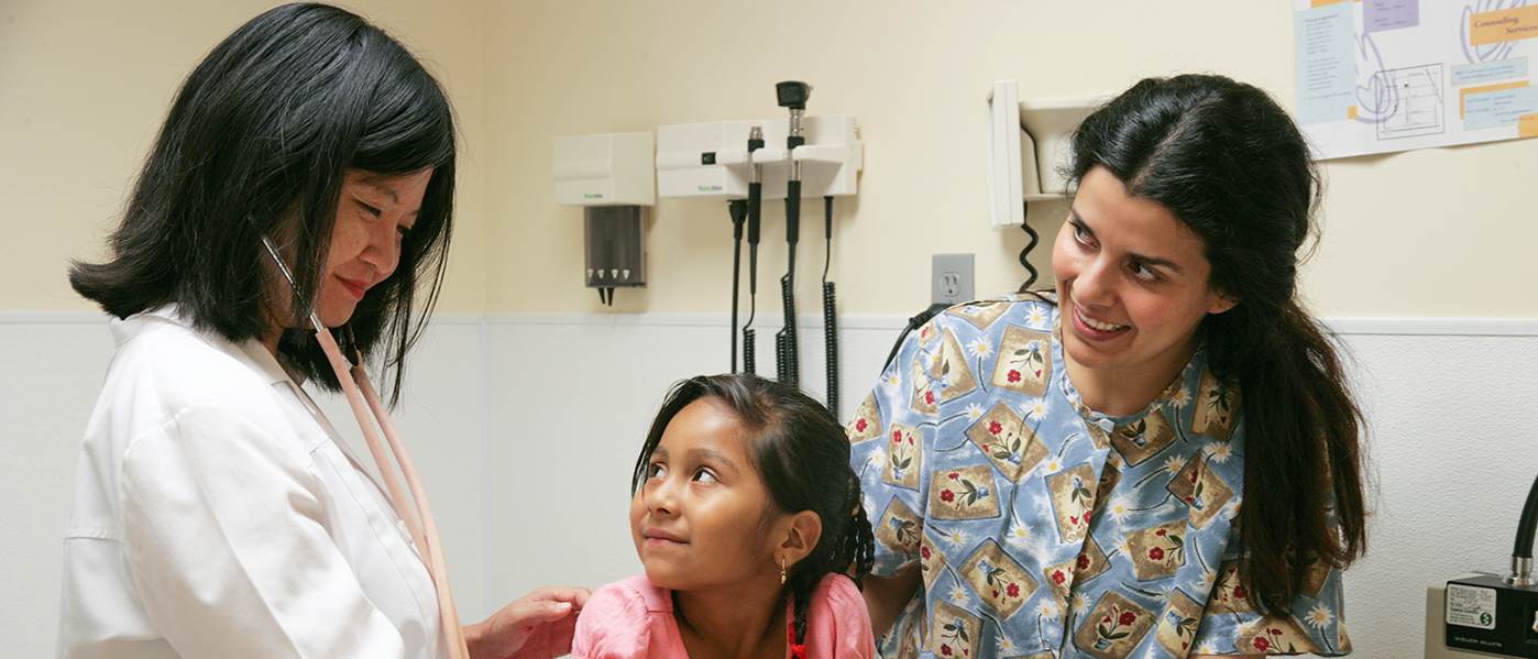 A doctor with a child patient and her mom