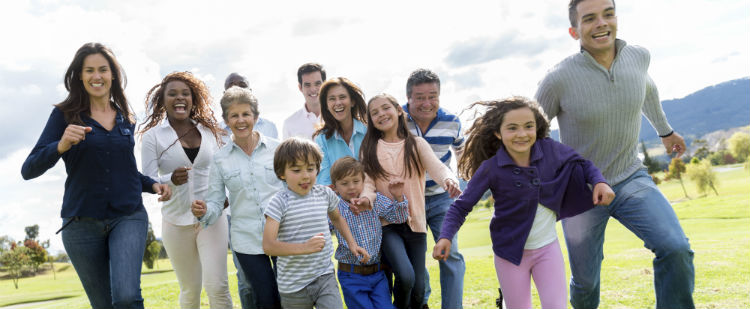 Multi-generational Hispanic family runs in a park