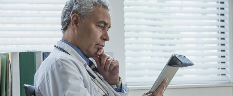 Health Care Provider reviewing electronic health record on tablet
