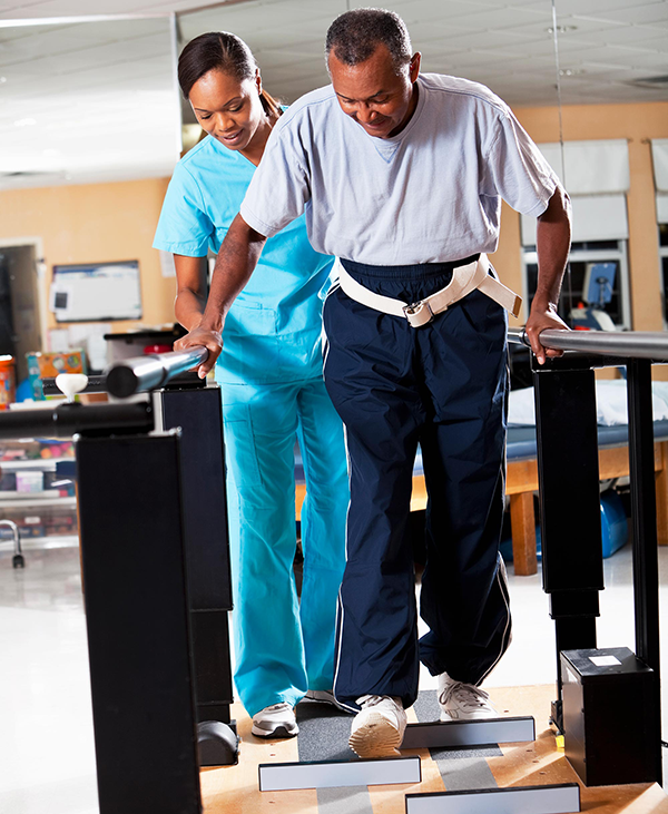 physical therapist helping a man to walk