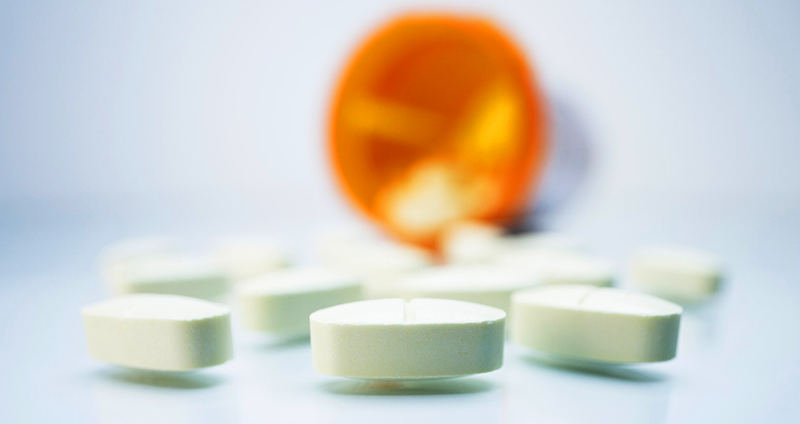 a prescription bottle and medication tablets