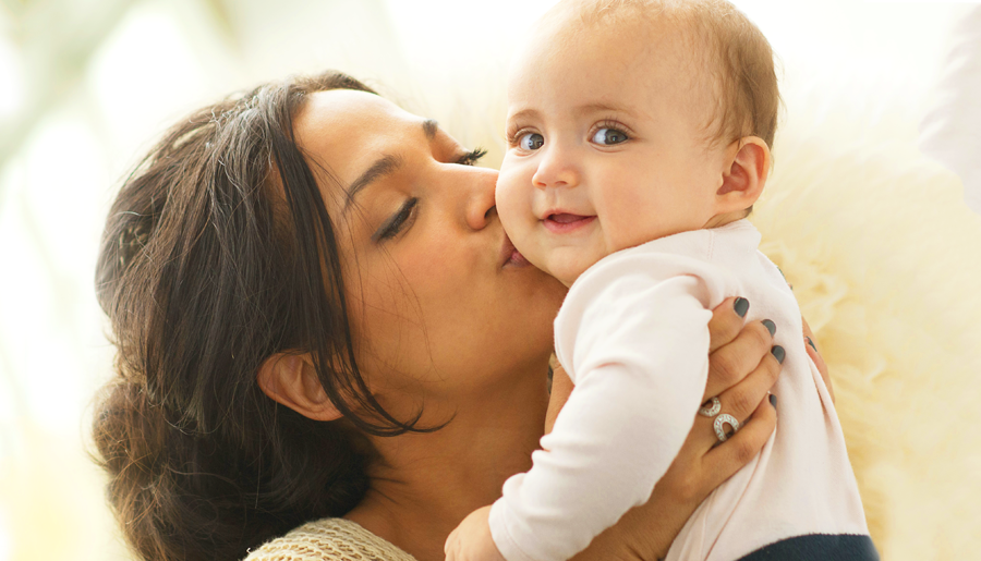 mother holding and kissing her baby