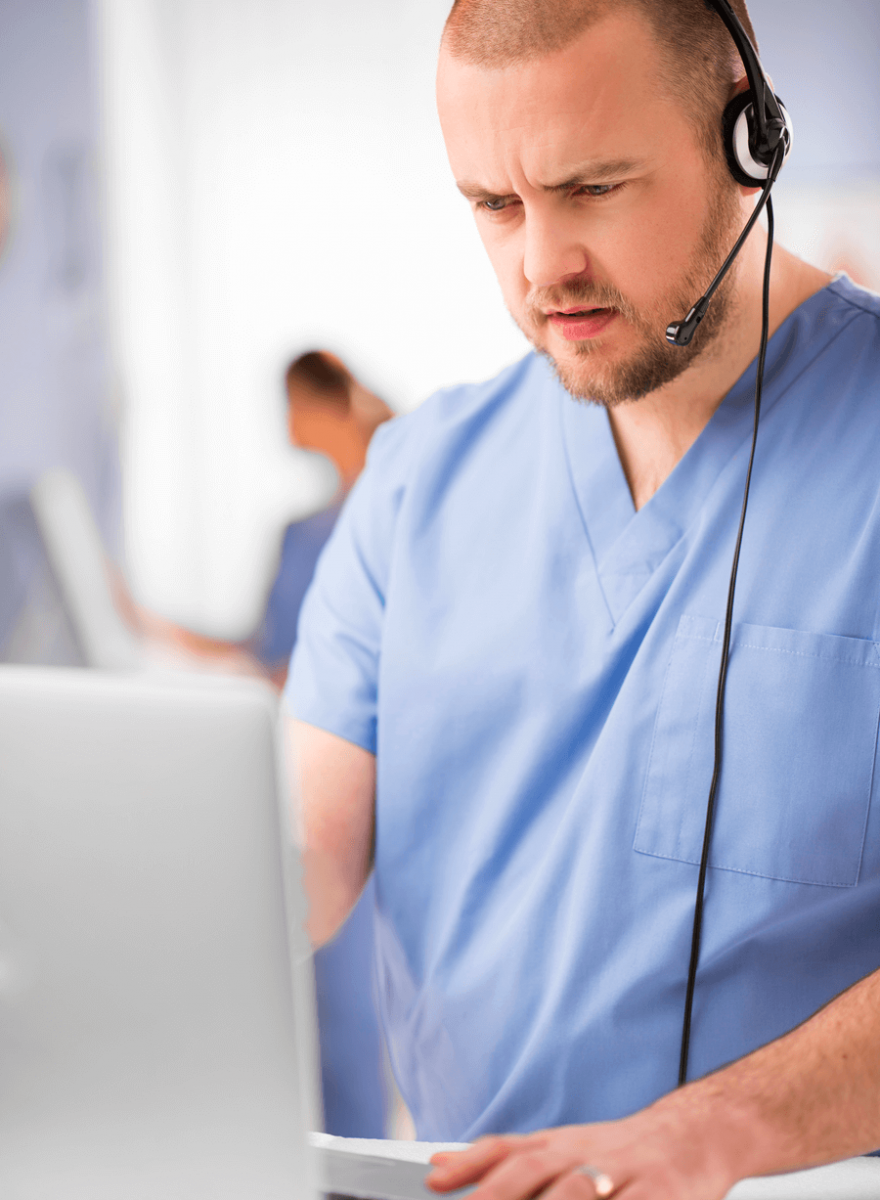 Nurse taking a call and looking at a laptop