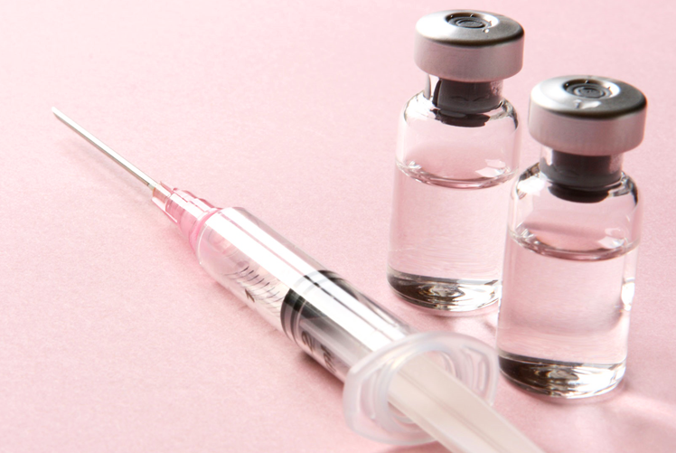 a syringe and two bottle of vaccine