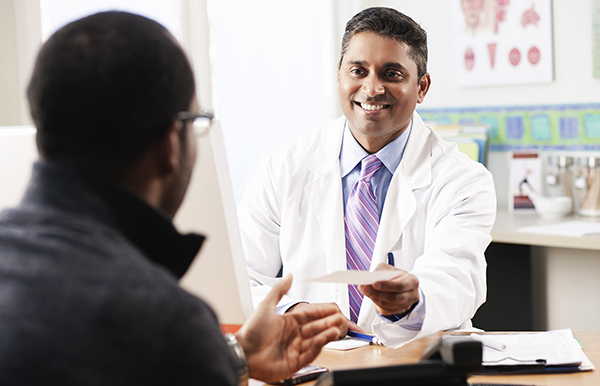 A doctor handing his patient a prescription