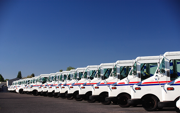 a line of U.S. postal trucks