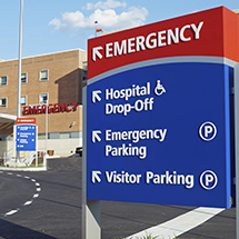 hospital sign pointing to hospital, emergency parking and visitor parking
