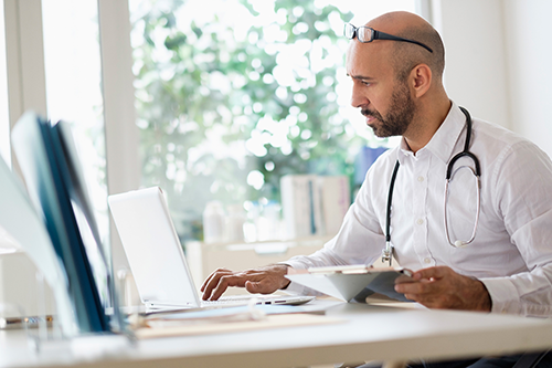 a doctor researching on his laptop