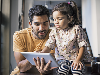 dad and daughter looking at tablet