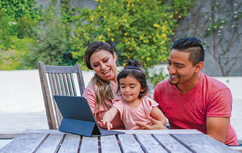 mom dad and baby looking at laptop