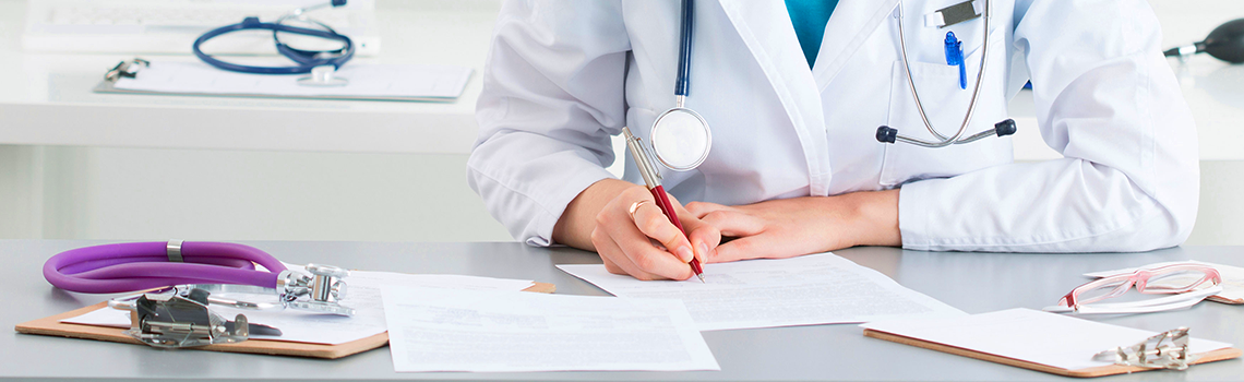 doctor filling out paperwork at her desk