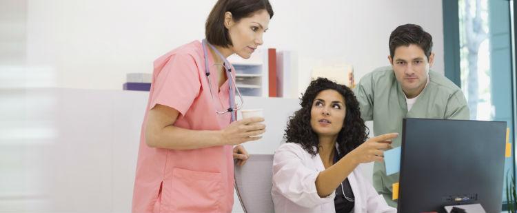 Physician and assistants review information on a laptop computer